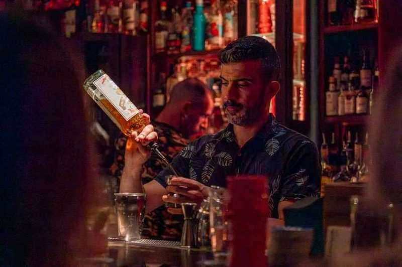 Bartender de Baba au Rum versant un spiritueux