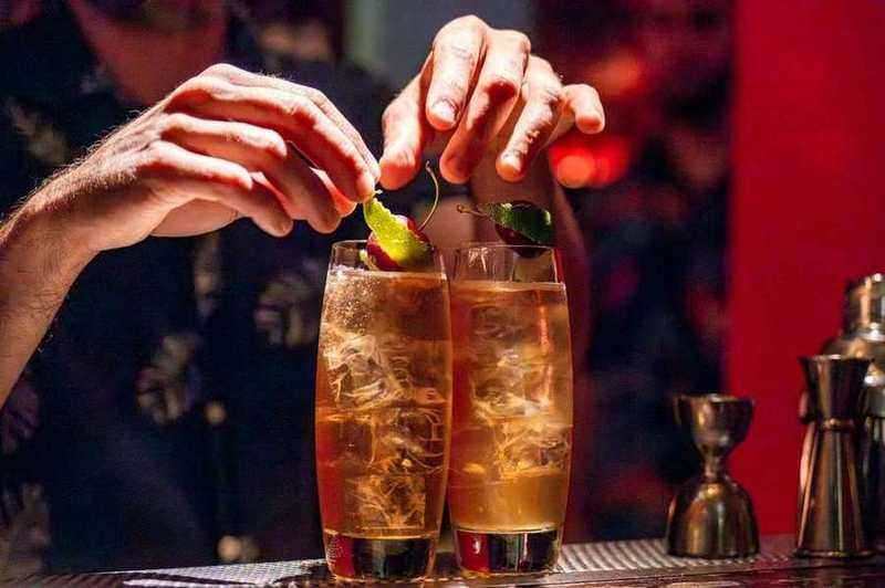 Bartender garnissant deux cocktails de cerises