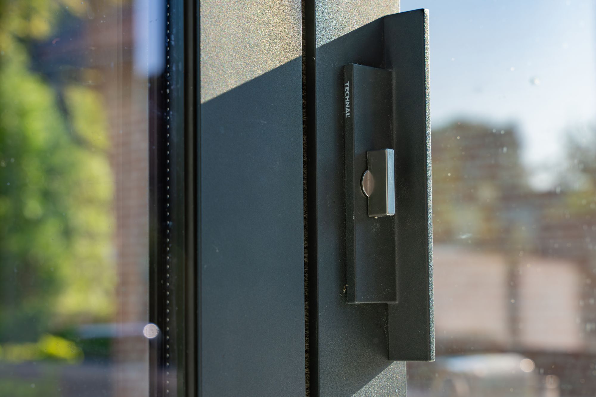 Poignée d’un ouvrant en aluminium anthracite en gros plan, Frechin