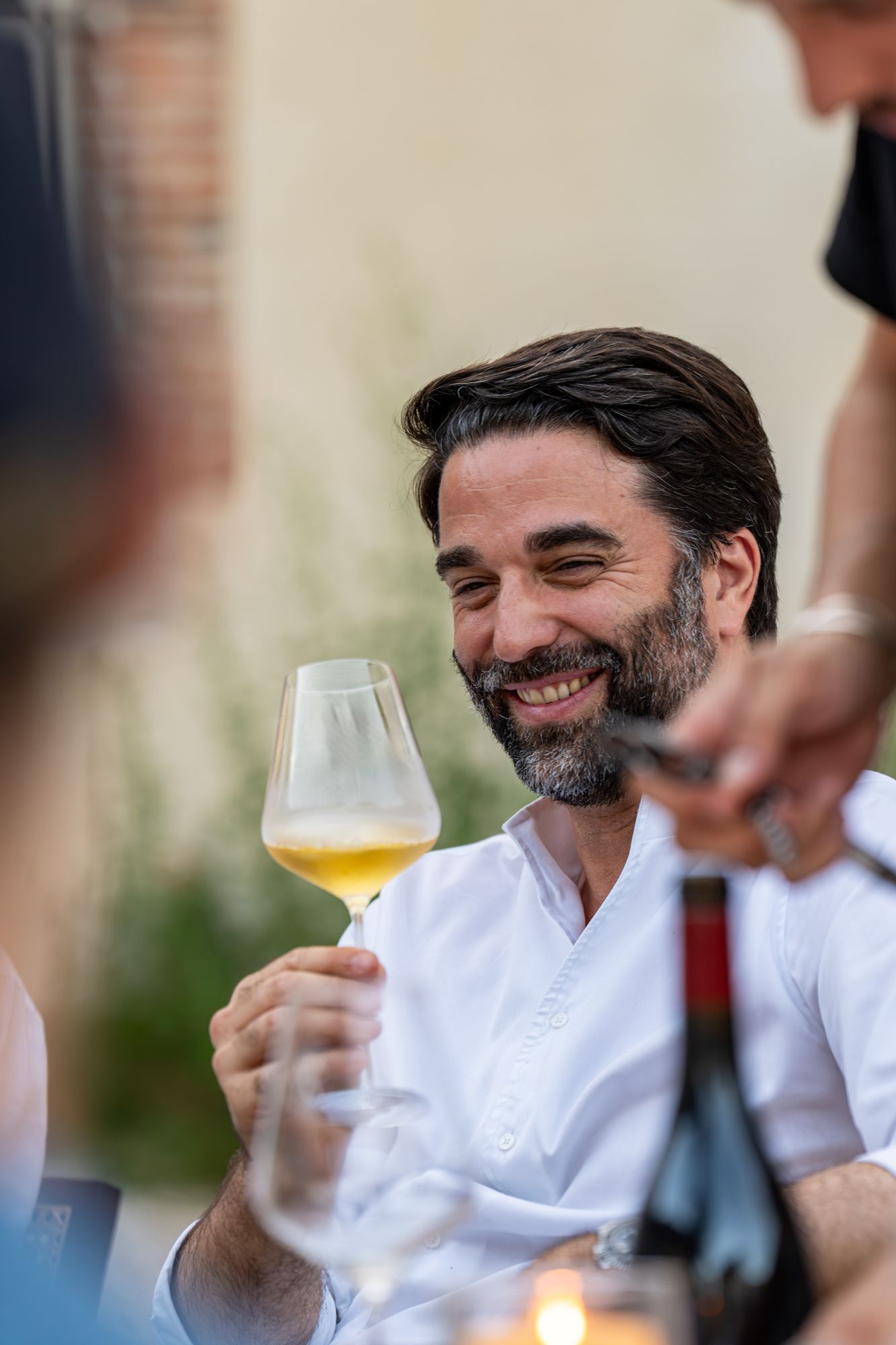 Chef souriant dégustant un champagne Frerejean Frères en terrasse