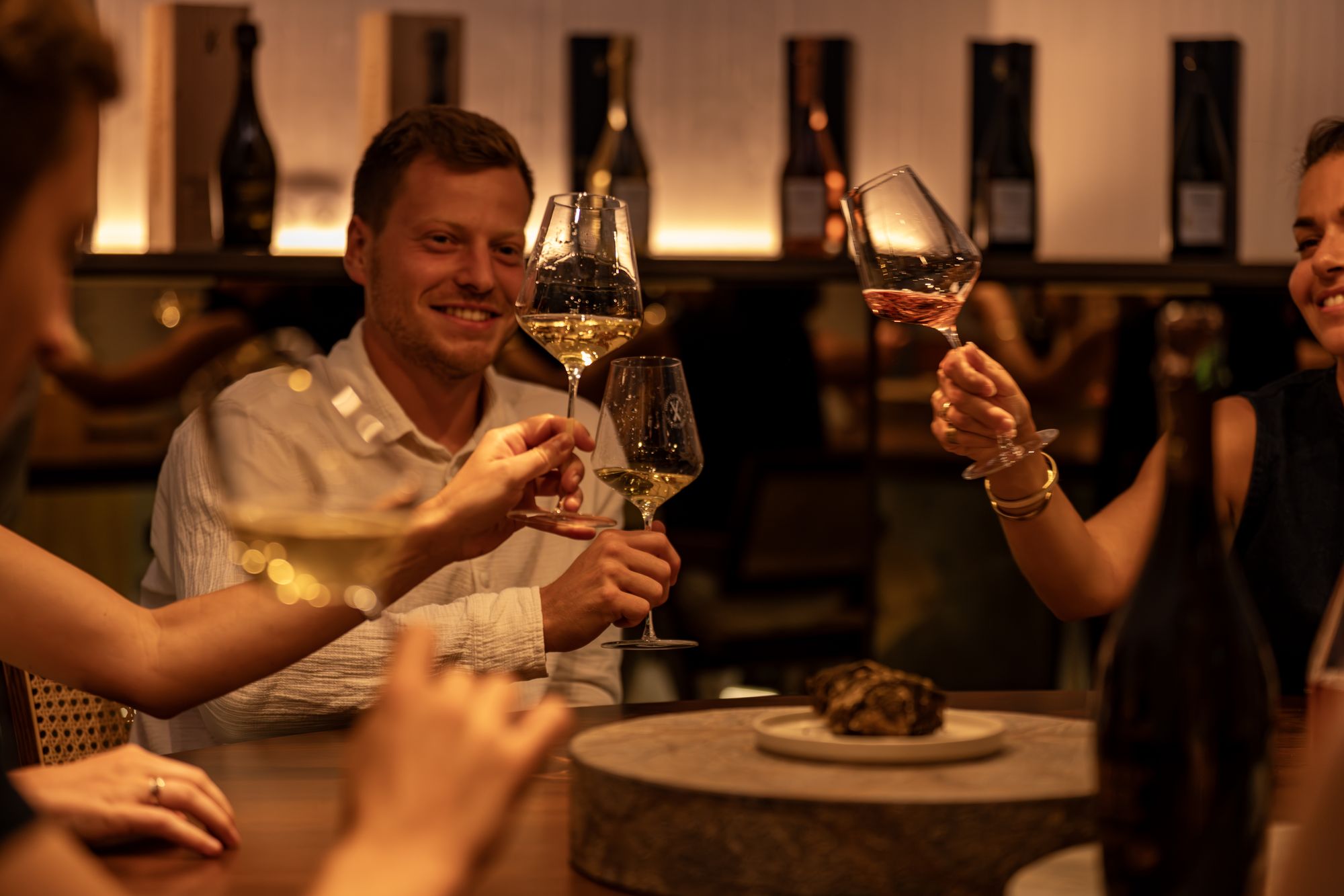 Convives trinquant avec des verres de champagne Frerejean Frères dans une salle de dégustation