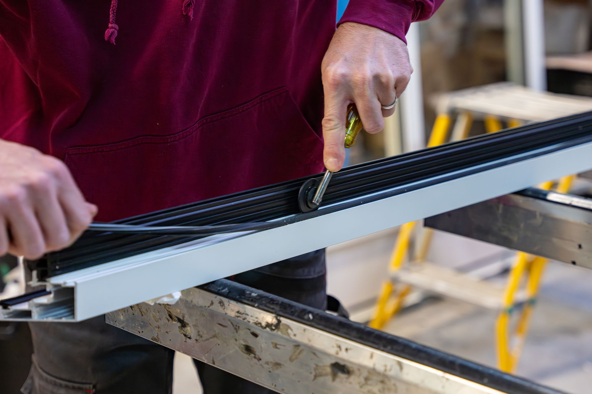 Pose d’un joint sur un profilé aluminium noir, Menuiserie Janin