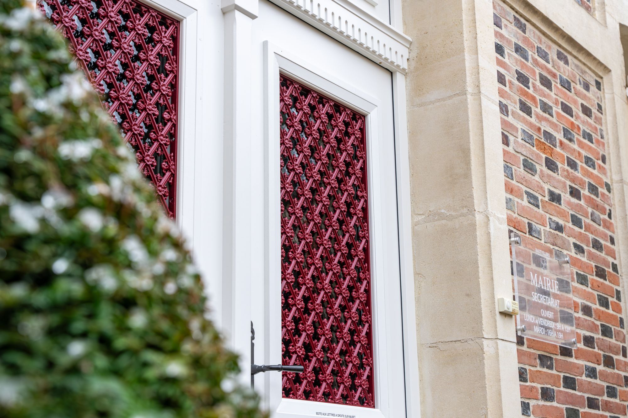 Porte blanche avec grille ouvragée rouge, Menuiserie Janin