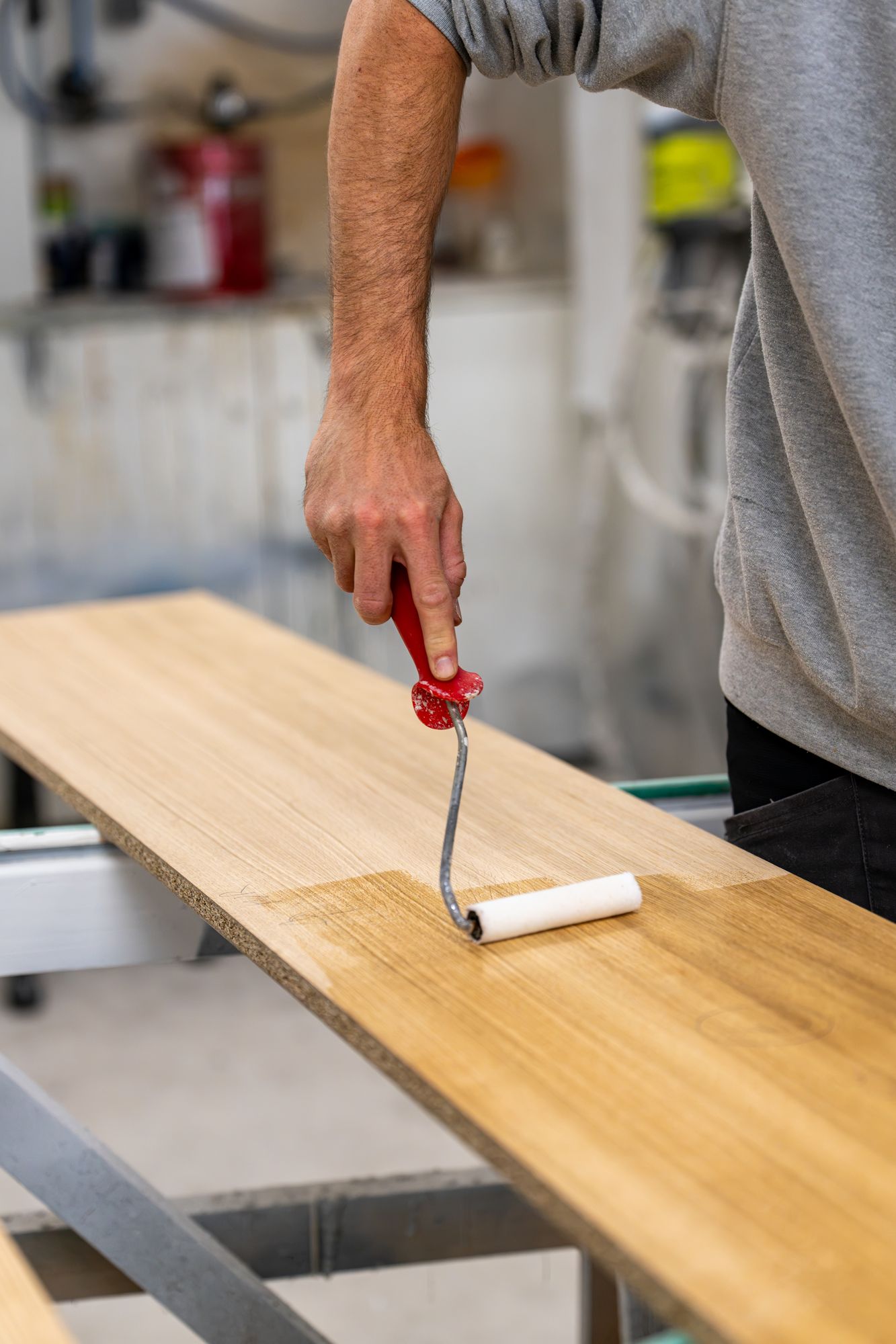 Application de vernis au rouleau sur un plateau de bois, Menuiserie Janin
