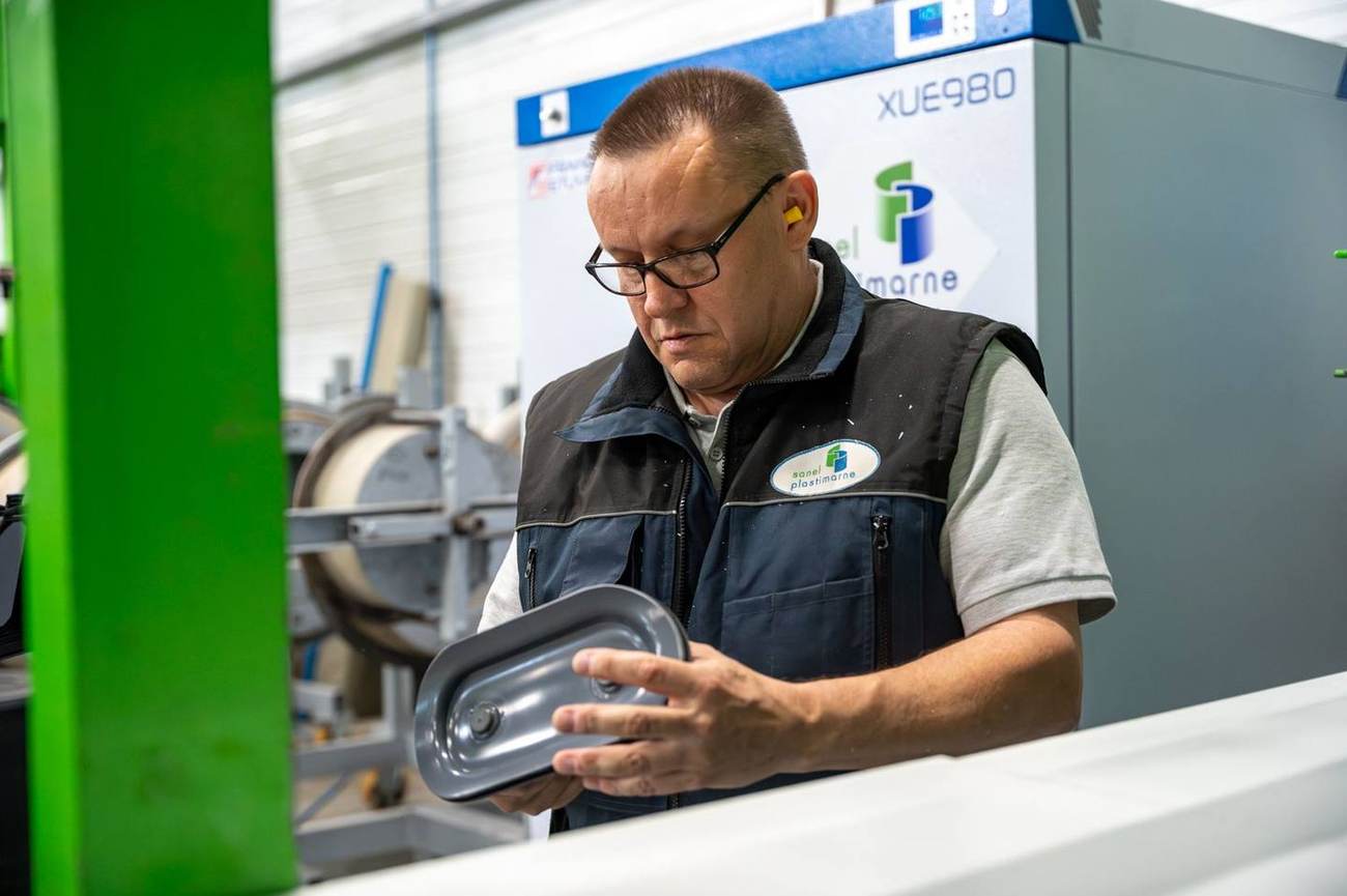 Technicien Sanel Plastimarne examinant une pièce composite